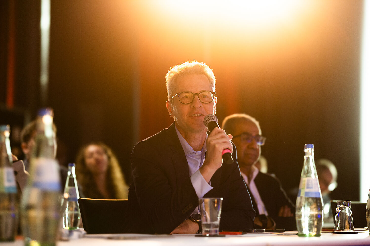 Delegate asking a question with microphone in conference room at ALSC Europe 2026.